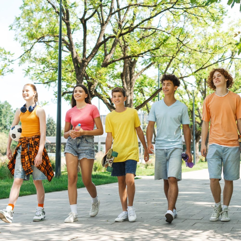 Portrait,Group,Of,Teenager,Friends,Walking,In,The,Park,Holding